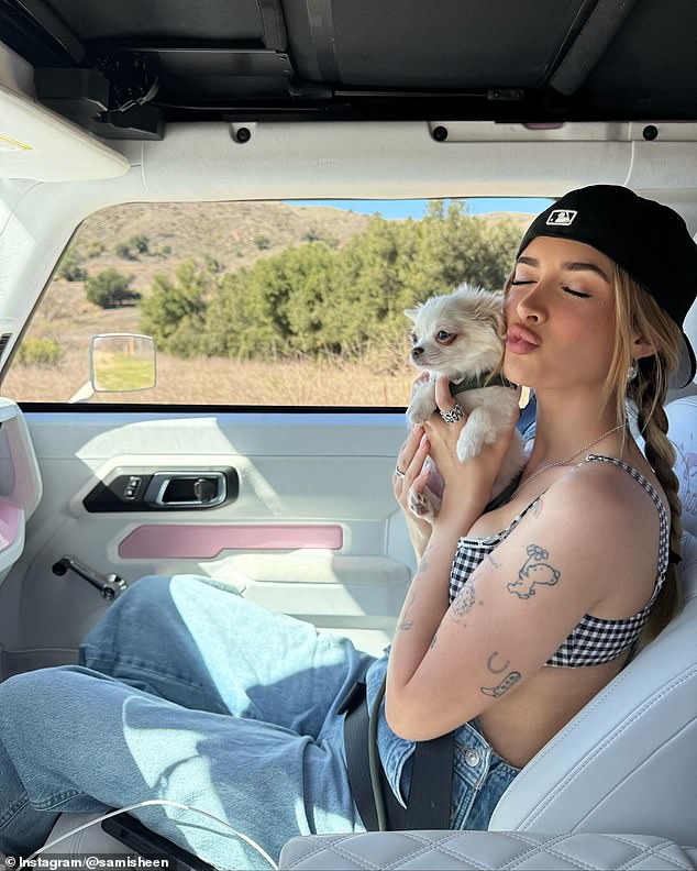 Sheen also posed with her small dog while in a car with a white and pink interior