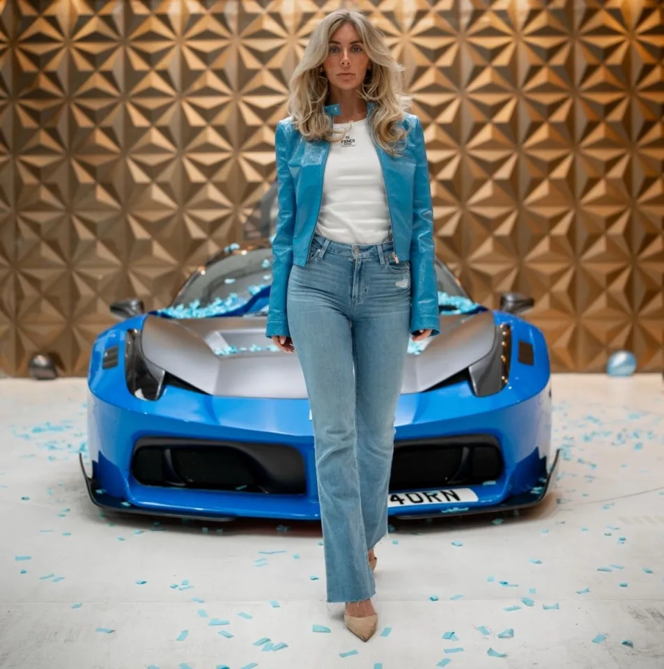 Woman standing in front of a blue Ferrari.