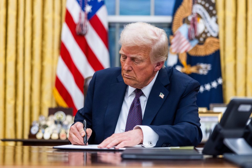 President Trump signing documents in the Oval Office.