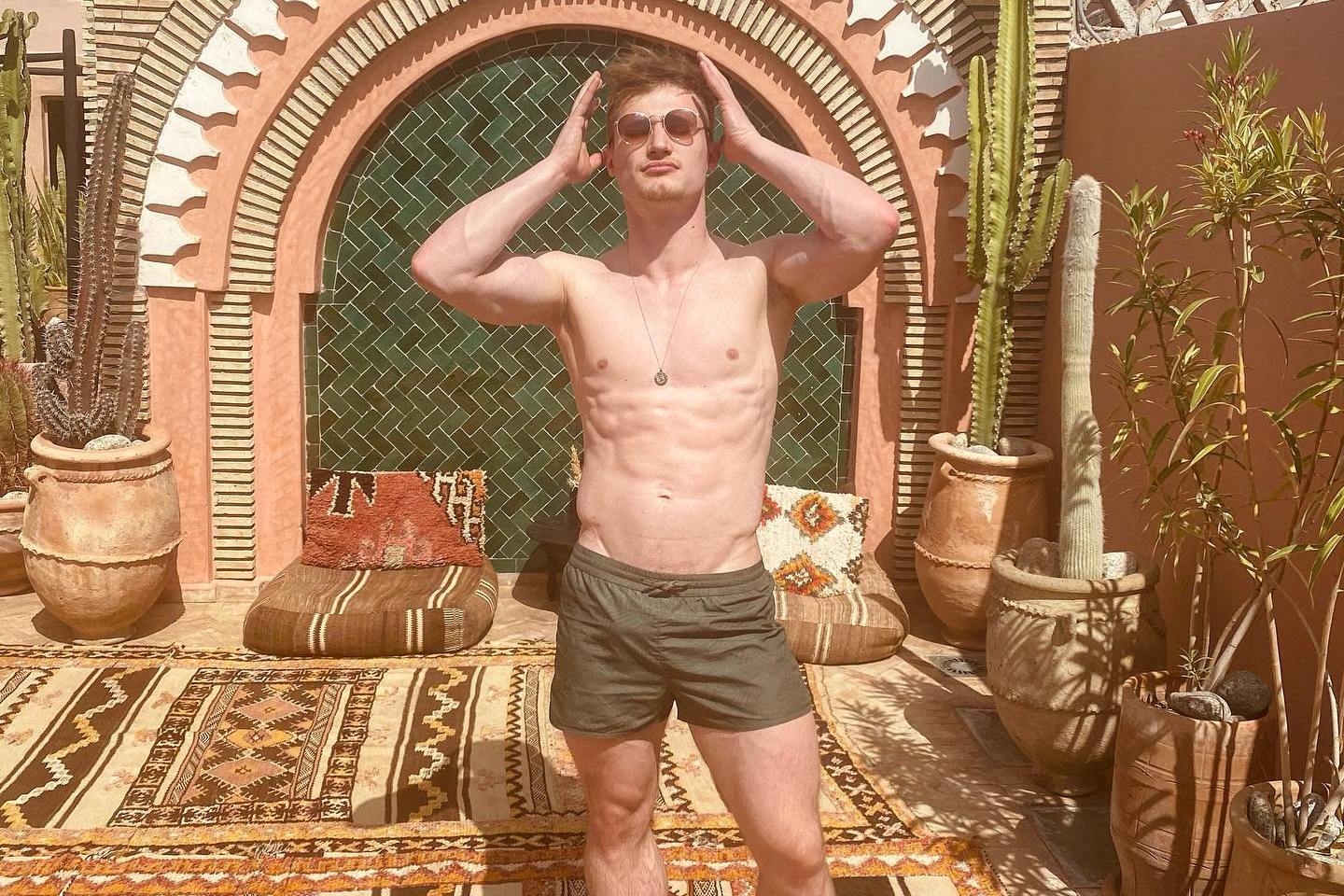Man posing on a rooftop terrace.