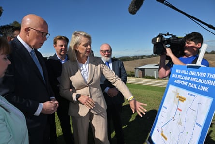 The politicians and others examine a large map of the rail link
