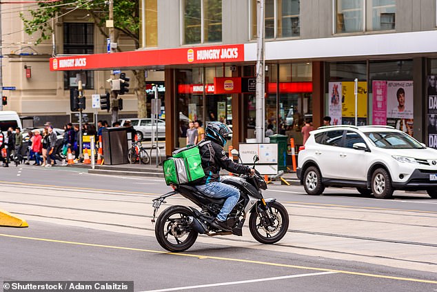 Australians working side hustle jobs are set to get a rude tax bill as the government cracks down on gig economy roles (pictured is a Menulog delivery rider in Melbourne)